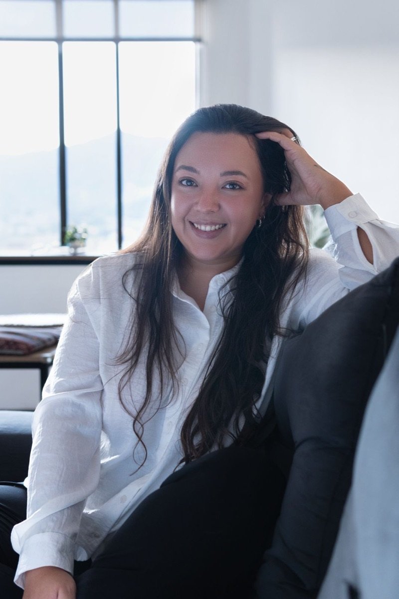 Laura Liévano smiling, seated by a window
